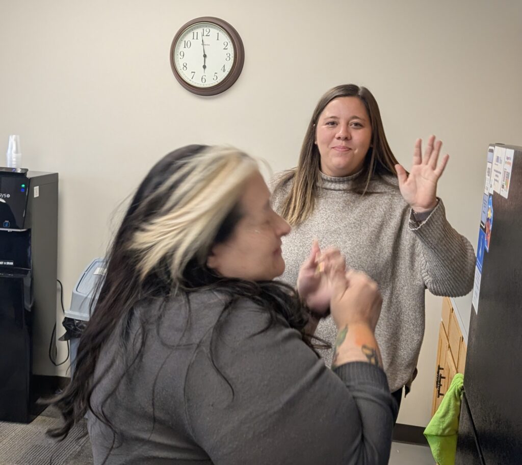 2 LOSS Team members laughing and waving